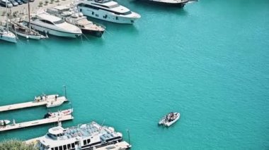 Nice, Fransa 'daki liman manzarası. Demirlemiş yatlar, insanlarla hareket eden tekneler, Akdeniz 'in mavi suları.