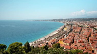 Nice, Fransa 'daki Cote d' Azur manzarası. Sahilde dinlenen insanlar, binalar, Akdeniz 'in mavi suları.