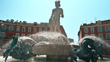 GÜZEL, FRANCE - 8 AĞUSTOS 2021: fıskiyeli ve heykelli merkez meydan, insanlar, güneşli bir günde klasik binalar