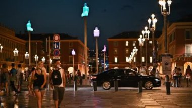 GÜZEL, FRANCE - 8 AĞUSTOS 2021: Birden fazla insanla merkez meydan, geceleri klasik binalar