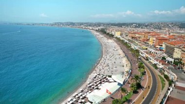 Güzel, FRANCE - 8 Ağustos 2021: cote d 'Azur manzarası. Sahilde dinlenen insanlar, binalar, Akdeniz 'in mavi suları.