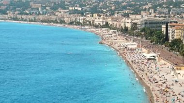 Güzel, FRANCE - 8 Ağustos 2021: cote d 'Azur manzarası. Sahilde dinlenen insanlar, binalar, Akdeniz 'in mavi suları.
