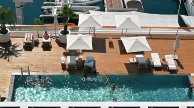 Monako - 21 AĞUSTOS 2021 Deniz kıyısında yüzen ve dinlenen insanlarla dolu bir otel