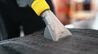 Araba yıkamada temizlikçiyim. Profesyonel bir elektrikli süpürge kullanarak halı temizlemek. Yavaş çekim