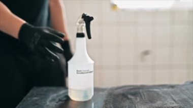 CHISINAU, MOLDOVA - 6 Eylül 2021: oto yıkamada çalışan temizlikçi. Kimyasal solüsyonlu bir sprey. Yavaş çekim