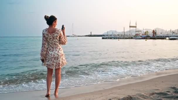 Ξανθιά Γυναίκα Πυροβολεί Στο Smartphone Της Στην Παραλία Στις Ακτές — Αρχείο Βίντεο