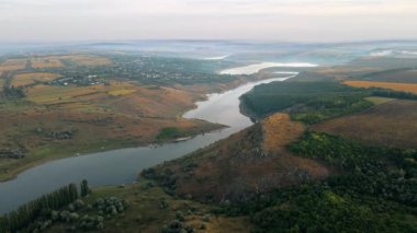 Moldova 'daki Duruitoarea doğal rezervasyonunun hava aracı görüntüsü. Nehir ve sis havada, tepeler ve tarlalar, köy