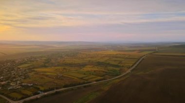 Gün batımında Moldova 'da doğanın insansız hava aracı görüntüsü. Köy, tarlalar ve tepeler