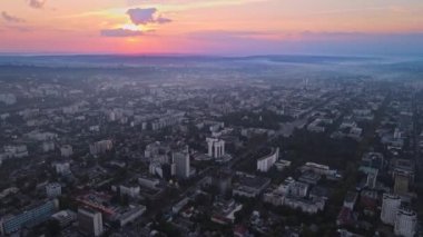 Chisinau 'nun günbatımında hava aracı görüntüsü. Birden fazla bina ve yol manzaralı. Moldova