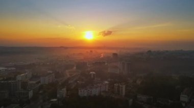 Chisinau 'nun güneş doğarken hava aracı görüntüsü. Birden fazla bina ve yol manzaralı. Moldova