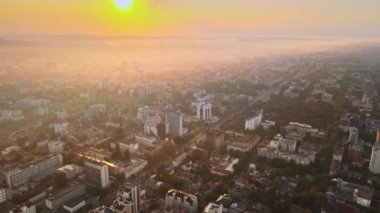 Chisinau 'nun güneş doğarken hava aracı görüntüsü. Birden fazla bina ve yol manzaralı. Moldova