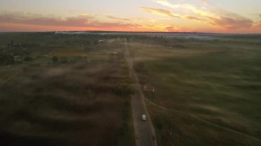 Gün batımında Moldova 'daki köyün insansız hava aracı görüntüsü. Yangınlardan ve geniş alanlardan dumanlar yükseliyor.