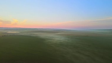 Gün batımında Moldova 'daki köyün insansız hava aracı görüntüsü. Yangınlardan, geniş tarlalardan ve havada sis bulutlarından dumanlar yükseliyor.