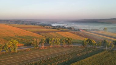 Gün batımında Moldova 'daki köyün insansız hava aracı görüntüsü. Yangınlardan ve geniş alanlardan dumanlar yükseliyor.