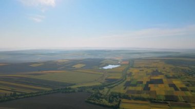 Moldova 'da güneşli havalarda doğanın insansız hava aracı görüntüsü. Geniş araziler, tepeler, göl ve yollar