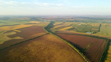 Gün batımında Moldova 'da doğanın insansız hava aracı görüntüsü. Geniş araziler, köy, yol