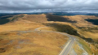 Romanya 'da doğanın insansız hava aracı görüntüsü. Karpat dağları, seyrek bitki örtüsü, arabalı Transalpina yolu.