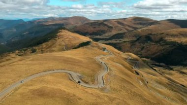 Romanya 'da doğanın insansız hava aracı görüntüsü. Karpat dağları, seyrek bitki örtüsü, arabalı Transalpina yolu.