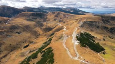 Romanya 'da doğanın insansız hava aracı görüntüsü. Karpat dağları, seyrek bitki örtüsü, arabalı Transalpina yolu.