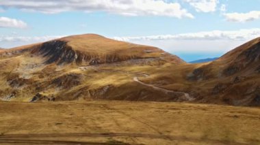Romanya 'da doğanın insansız hava aracı görüntüsü. Karpat dağları, seyrek bitki örtüsü, arabalı Transalpina yolu.