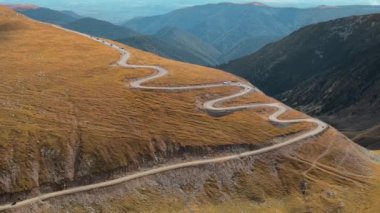 Romanya 'da doğanın insansız hava aracı görüntüsü. Karpat dağları, seyrek bitki örtüsü, arabalı Transalpina yolu.