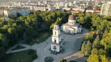 Chisinau 'nun gün batımında hava aracı görüntüsü. Central Park manzarası, Katedral, çan kulesi, bir sürü yeşillik, yürüyen insanlar, binalar. Moldova