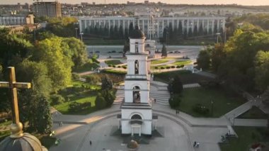 Chisinau 'nun gün batımında hava aracı görüntüsü. Hükümet binasının panorama manzarası, Zafer Kemeri, Katedral ve çan kulesi, yürüyen insanlar. Moldova