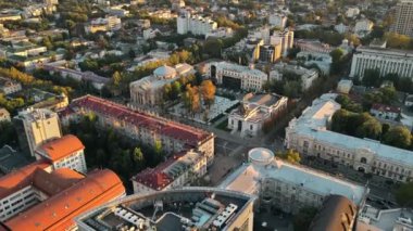 CHISINAU, MOLDOVA - 9 Eylül 2021: günbatımında şehir merkezinin hava aracı görüntüsü. Birden fazla binanın manzarası, Organ Salonu, hareket eden arabaları ve gür ağaçları olan yol.