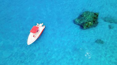Yunanistan 'ın Zakynthos kıyısında demirlemiş bir teknenin insansız hava aracı görüntüsü. İyon denizinin mavi ve şeffaf suları