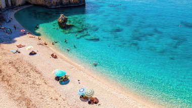 Yunanistan 'ın Zakynthos kentindeki İyon Denizi kıyılarının insansız hava aracı görüntüsü. Dinlenen insanlarla plaj, mavi su.
