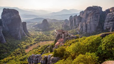 Meteora 'nın günbatımında Yunanistan' daki hava aracı görüntüsü. Ortodoks manastırlı kaya oluşumları. Bir sürü yeşillik, kutsal bir yer