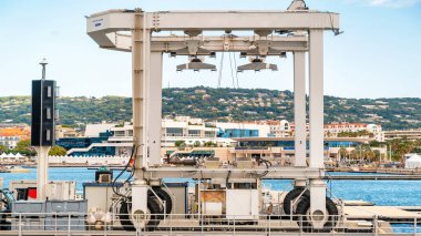 CANES, FRANCE - 2 Eylül 2021: deniz limanı manzarası. Makine, Akdeniz 'in mavi suyu, arka planda şehir manzarası.