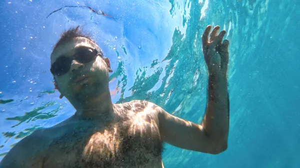 Człowiek Goglach Pływa Pod Błękitną Przejrzystą Wodą Morza Śródziemnego Trzymając — Zdjęcie stockowe
