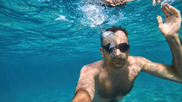 Człowiek Goglach Pływa Pod Błękitną Przejrzystą Wodą Morza Śródziemnego Trzymając — Zdjęcie stockowe