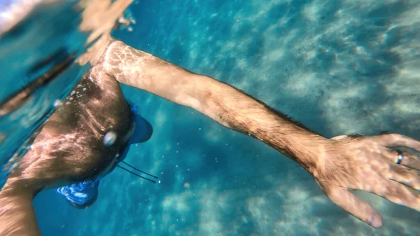 Człowiek Pływa Błękitnej Przejrzystej Wodzie Morza Śródziemnego Trzymając Kamerę — Zdjęcie stockowe