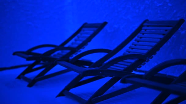 Liegestühle in einem Salzraum mit blauem Licht