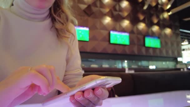 Kvinne Som Jobber Med Mobiltelefon Restaurant Skjermer Med Fotball – stockvideo