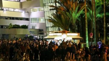 CANNES, FRANCE - 26 AĞUSTOS 2021: Yürüyen insanlarla dolu bir cadde, gece lambaları, avuçlar