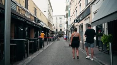 CANNES, FRANCE - 28 AĞUSTOS 2021: Yürüyen insanlarla, kafelerle ve dükkanlarla dolu bir yaya sokağı. Yavaş çekim