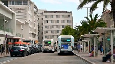 CANNES, FRANCE - 28 AĞUSTOS 2021: Park etmiş arabaların, otobüslerin, istasyonlarda insanların olduğu cadde. Yavaş çekim