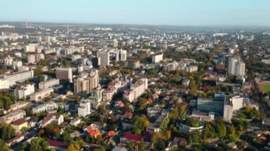 Chisinau 'nun gün batımında hava aracı görüntüsü. Birden fazla binanın manzarası, yemyeşil ağaçlı yollar. Moldova