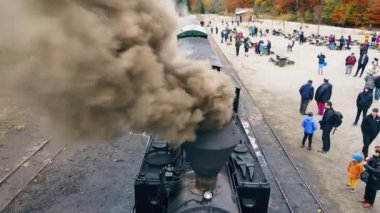 VISEU DE SUS, ROMANIA - 29 Ekim 2021: Buharlı Mocanita treninin hava aracı görüntüsü ve tren istasyonunda bir sürü turist