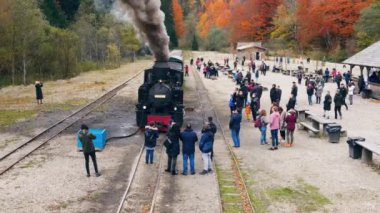 VISEU DE SUS, ROMANIA - 29 Ekim 2021: Buharlı Mocanita treninin hava aracı görüntüsü ve tren istasyonunda bir sürü turist