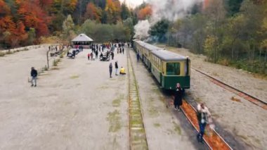 VISEU DE SUS, ROMANIA - 29 Ekim 2021: Buharlı Mocanita treninin hava aracı görüntüsü ve tren istasyonunda bir sürü turist