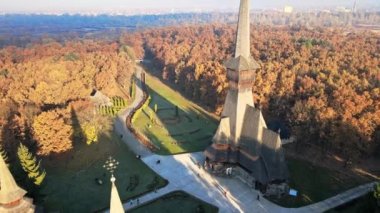 Romanya 'nın güneş doğarken Peri-Sapanta Manastırı' nın insansız hava aracı görüntüsü. Ana kilise ve bir bina, ziyaretçiler, sararmış ormanlar.
