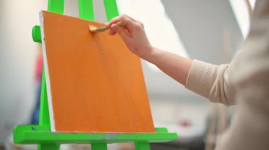 Stüdyoda fırçayla resim yapan bir kadın. Yavaş çekim