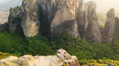 Meteora 'nın günbatımında Yunanistan' daki hava aracı görüntüsü. İnsanlarla dolu kaya oluşumları. Bir sürü yeşillik, kutsal bir yer