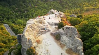 Meteora 'nın günbatımında Yunanistan' daki hava aracı görüntüsü. İnsanlarla dolu kaya oluşumları. Bir sürü yeşillik, kutsal bir yer