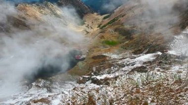 Romanya 'da doğanın insansız hava aracı görüntüsü. Karpatya dağlarındaki transfagarasan rotası, Balea Gölü tatil beldesi ve karla kaplı kayalık yamaçlar, vadi, bulut
