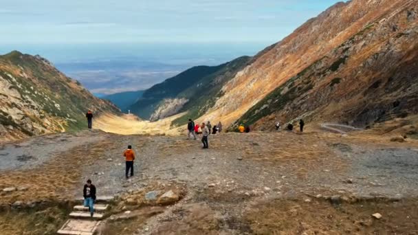 Transfagarasan Romania 2021年10月16日 自然の空中ドローンビュー カルパチア山脈のトランスファガラーサンルート 岩の斜面近くで写真を撮る観光客のグループ — ストック動画